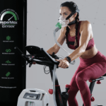 A woman on a stationary bike with a oxygen tube